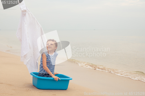 Image of One happy little boy playing on the beach at the day time.