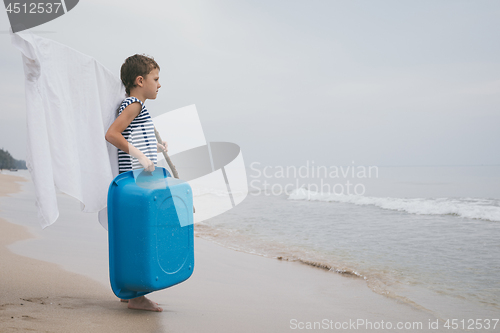 Image of One little boy playing on the beach at the day time.