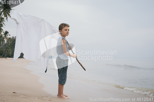 Image of One little boy playing on the beach at the day time.