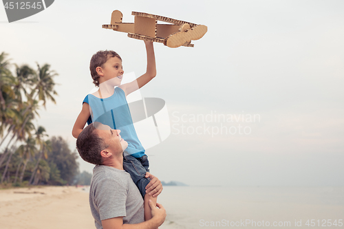 Image of Father and son playing with cardboard toy airplane