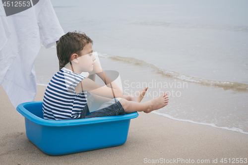 Image of One little boy playing on the beach at the day time.