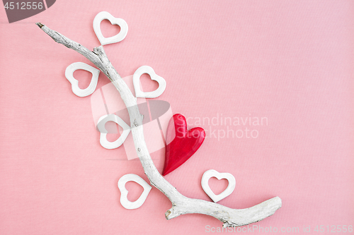 Image of Driftwood decorated with red and white wooden hearts