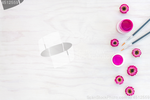 Image of Bright pink acrylic paint and flowers on white background