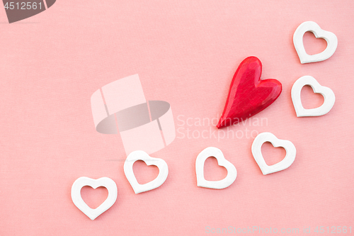 Image of Red and white wooden hearts on pink canvas