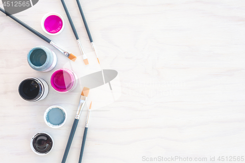 Image of Acrylic paint and paintbrushes on white background