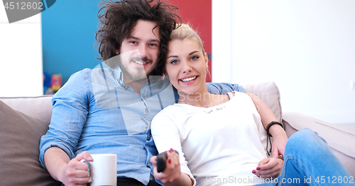 Image of Young couple on the sofa watching television