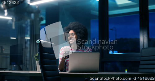 Image of black businesswoman using a laptop in night startup office