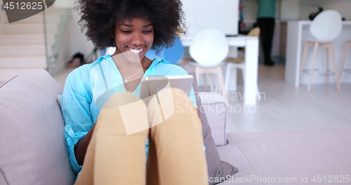 Image of african american woman at home using digital tablet