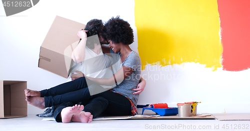 Image of young multiethnic couple playing with cardboard boxes