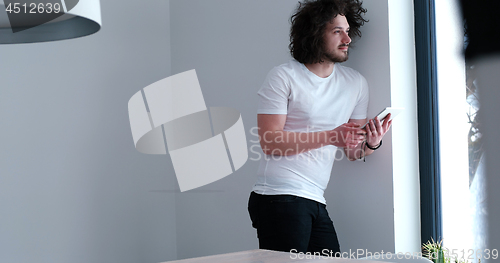 Image of young man using a tablet at home