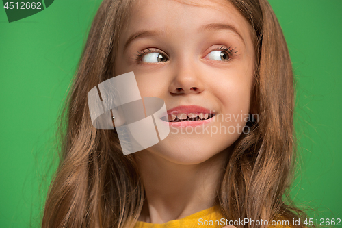 Image of The happy teen girl standing and smiling against green background.