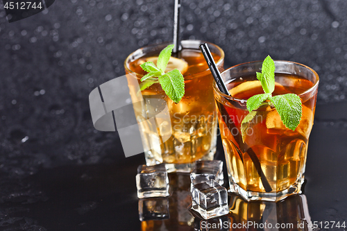 Image of Two glasses with cold traditional iced tea with lemon, mint leav