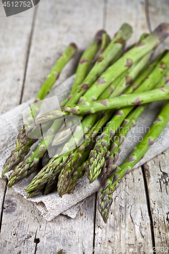 Image of Bunch of fresh raw garden asparagus closeup and linen napkin on 