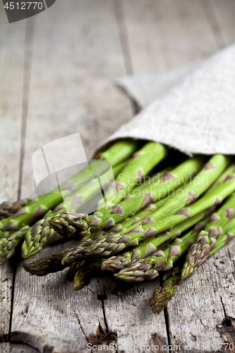 Image of Bunch of fresh raw garden asparagus closeup and linen napkin on 