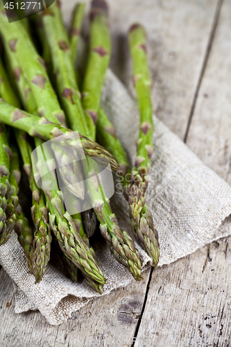 Image of Bunch of fresh raw garden asparagus closeup and linen napkin on 