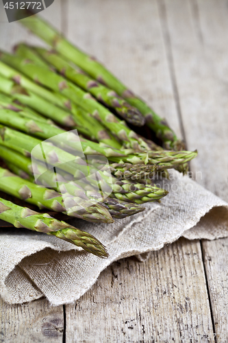 Image of Bunch of fresh raw garden asparagus closeup and linen napkin on 