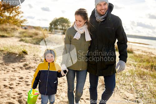 Image of happy family walking along autumn beach