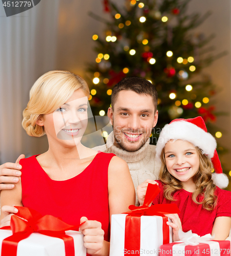 Image of happy family with christmas gifts at home