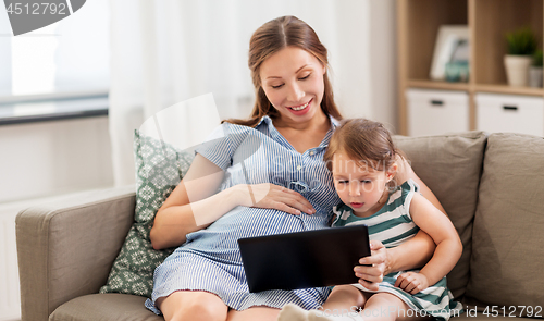 Image of pregnant mother and daughter with tablet pc