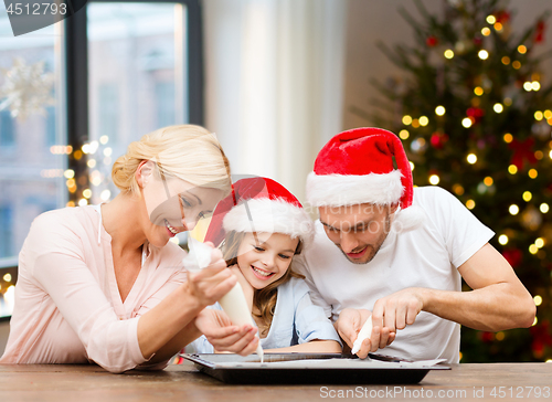 Image of family decorating bakery by frosting on christmas