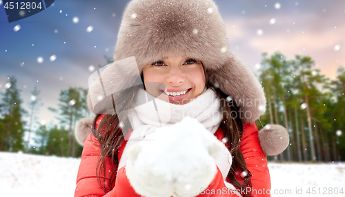 Image of woman in fur hat with snow over winter forest