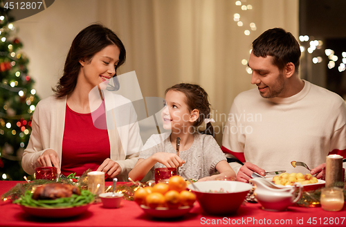 Image of happy family having christmas dinner at home