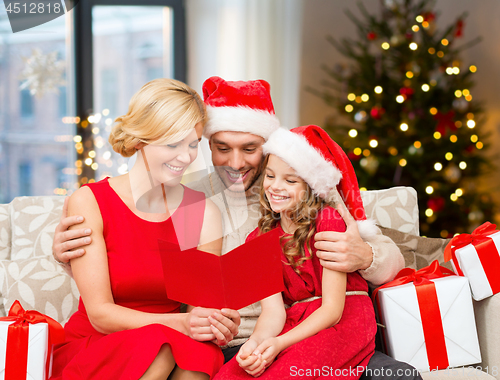 Image of happy family reading christmas greeting card