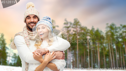 Image of couple hugging over winter forest background