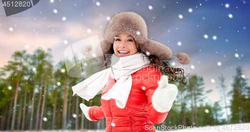 Image of happy woman in fur hat over winter forest