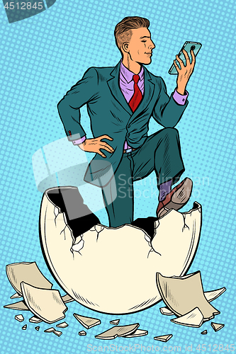 Image of The businessman was born from an egg. Reads news in the smartphone