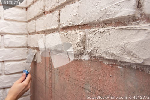 Image of Designer bricks with a spatula on the wall