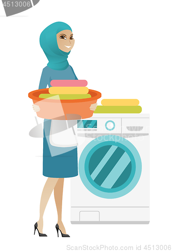 Image of Muslim housewife using washing machine at laundry.
