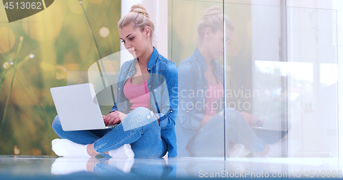 Image of young women using laptop computer on the floor