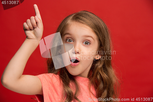 Image of Beautiful teen girl looking suprised isolated on red