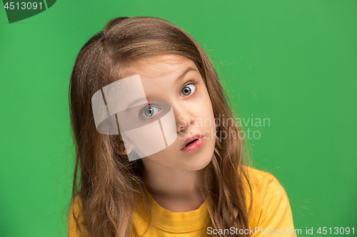 Image of Beautiful teen girl looking suprised isolated on green