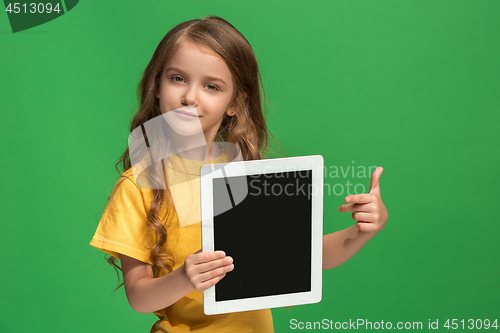 Image of Little funny girl with tablet on green background