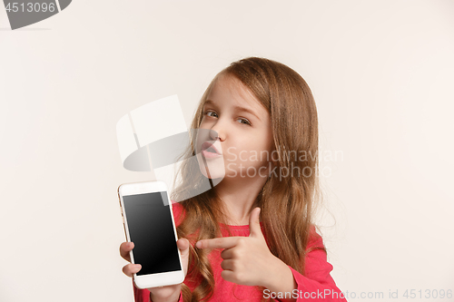 Image of The happy teen girl standing and smiling against white background.