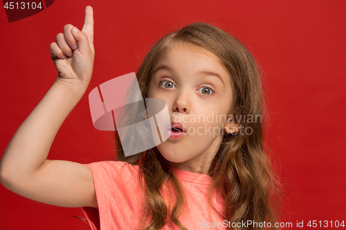 Image of Beautiful teen girl looking suprised isolated on red