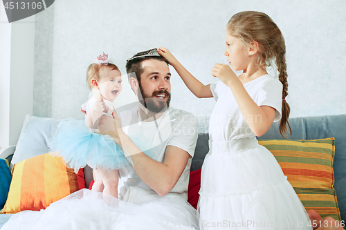 Image of The happy father and his baby daughters at home