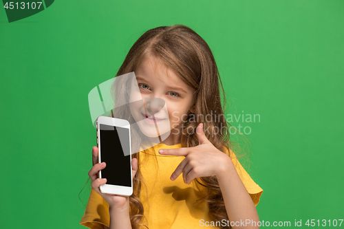 Image of The happy teen girl standing and smiling against green background.