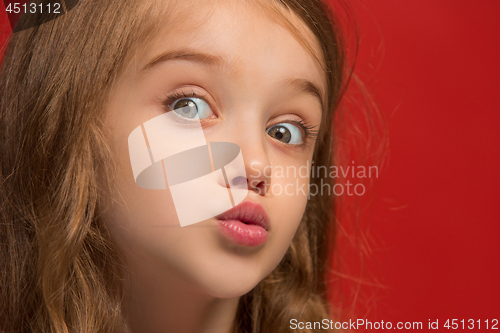 Image of Beautiful teen girl looking suprised isolated on red