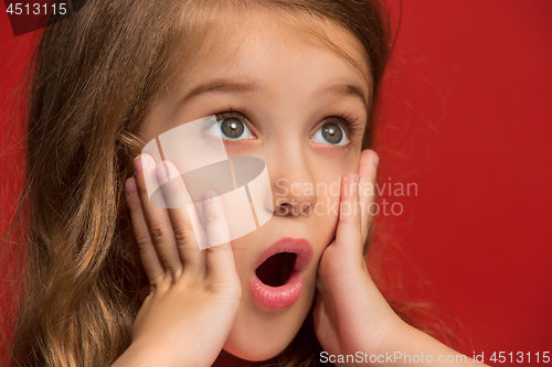 Image of Beautiful teen girl looking suprised isolated on red