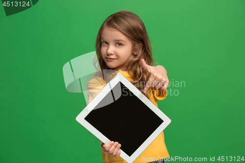 Image of Little funny girl with tablet on green background