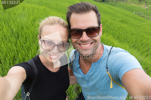 Image of Beautiful love couple having fun taking selfie at beautiful Jatiluwih rice terrace plantations on Bali, Indonesia, south east Asia.