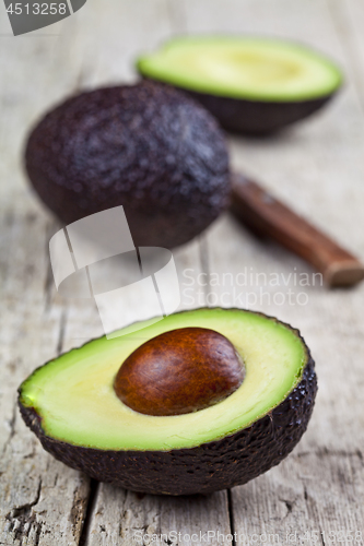 Image of Fresh avocado and knife on old wooden table background. Fresh av