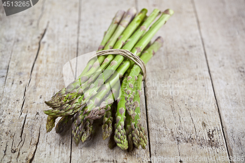 Image of Bunch of fresh raw garden asparagus on rustic wooden table backg