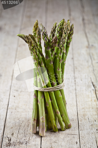 Image of Bunch of fresh raw garden asparagus on rustic wooden table backg