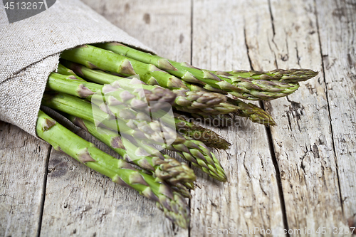 Image of Bunch of fresh raw garden asparagus closeup and linen napkin on 