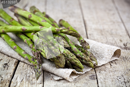 Image of Bunch of fresh raw garden asparagus closeup and linen napkin on 