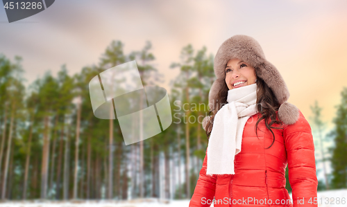 Image of happy woman in fur hat over winter forest